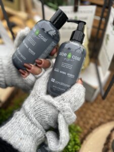 Hands holding shampoo and conditioner